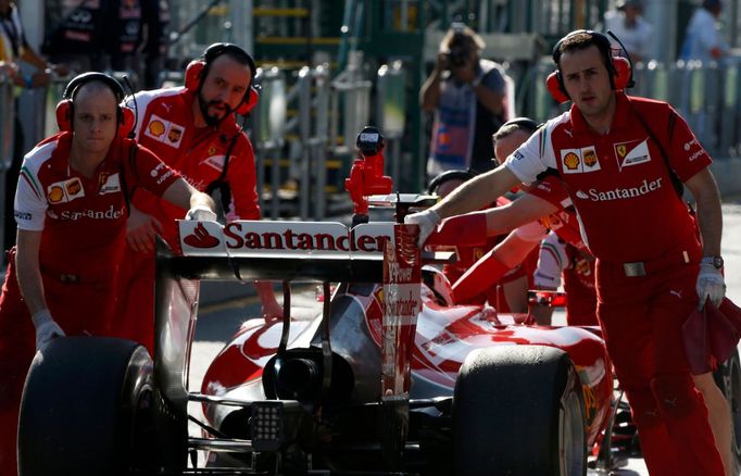 Mechanics push the car of Ferrari Formula One driver Kimi Raikkonen of Finland back into the garage during the second practice session of the Australian F1 Grand Prix at