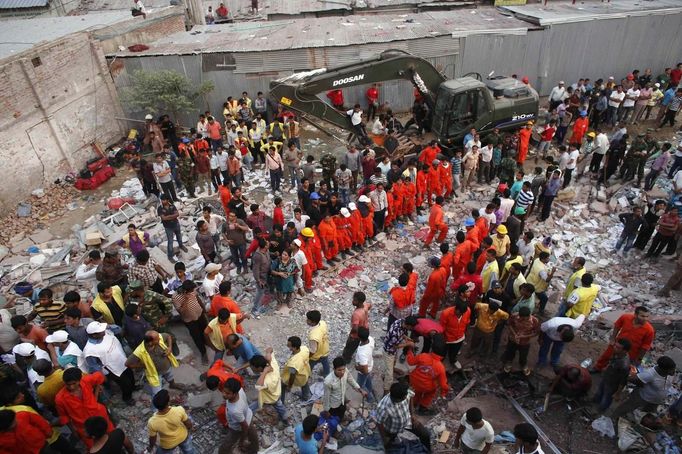 Rescue workers try to rescue trapped garment workers in the Rana Plaza building which collapsed, in Savar, 30 km (19 miles) outside Dhaka April 24, 2013. A block housing garment factories and shops collapsed in Bangladesh on Wednesday, killing nearly 100 people and injuring more than a thousand, officials said.REUTERS/Andrew Biraj (BANGLADESH - Tags: DISASTER BUSINESS) Published: Dub. 24, 2013, 3:34 odp.