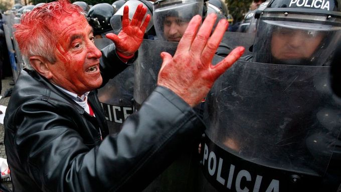 Muž, zraněný při protivládní demonstraci, spílá nasazeným pořádkovým policistům v centru Tirany.
