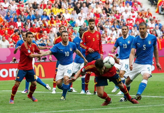 Xabi Alonso hlavičkouje před zraky hráčů obou týmů během utkání základní skupiny mezi Španělskem a Itálií na Euru 2012.