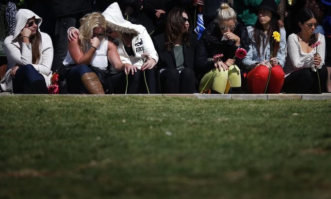 Women sitting at the Bali bombing memorial react during a commemoration ceremony marking the 10th anniversary of the 2002 Bali bombing, at Sydney's Coogee Beach October 12, 2012. Some 88 doves were released at the ceremony to symbolize the 88 Australians killed in the bombing of two nightclubs in Bali's Kuta district in 2002. REUTERS/Tim Wimborne (AUSTRALIA - Tags: CIVIL UNREST POLITICS ANNIVERSARY) Published: Říj. 12, 2012, 1:37 dop.