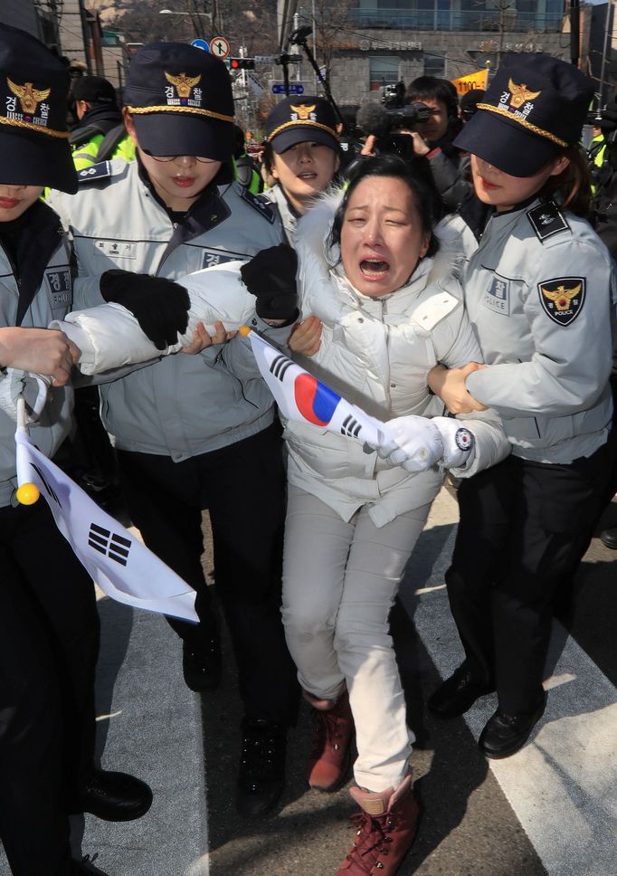 Lidé před soudní budovou reagují na odvolání jihokorejské prezidentky Pak Kun-hje z funkce.