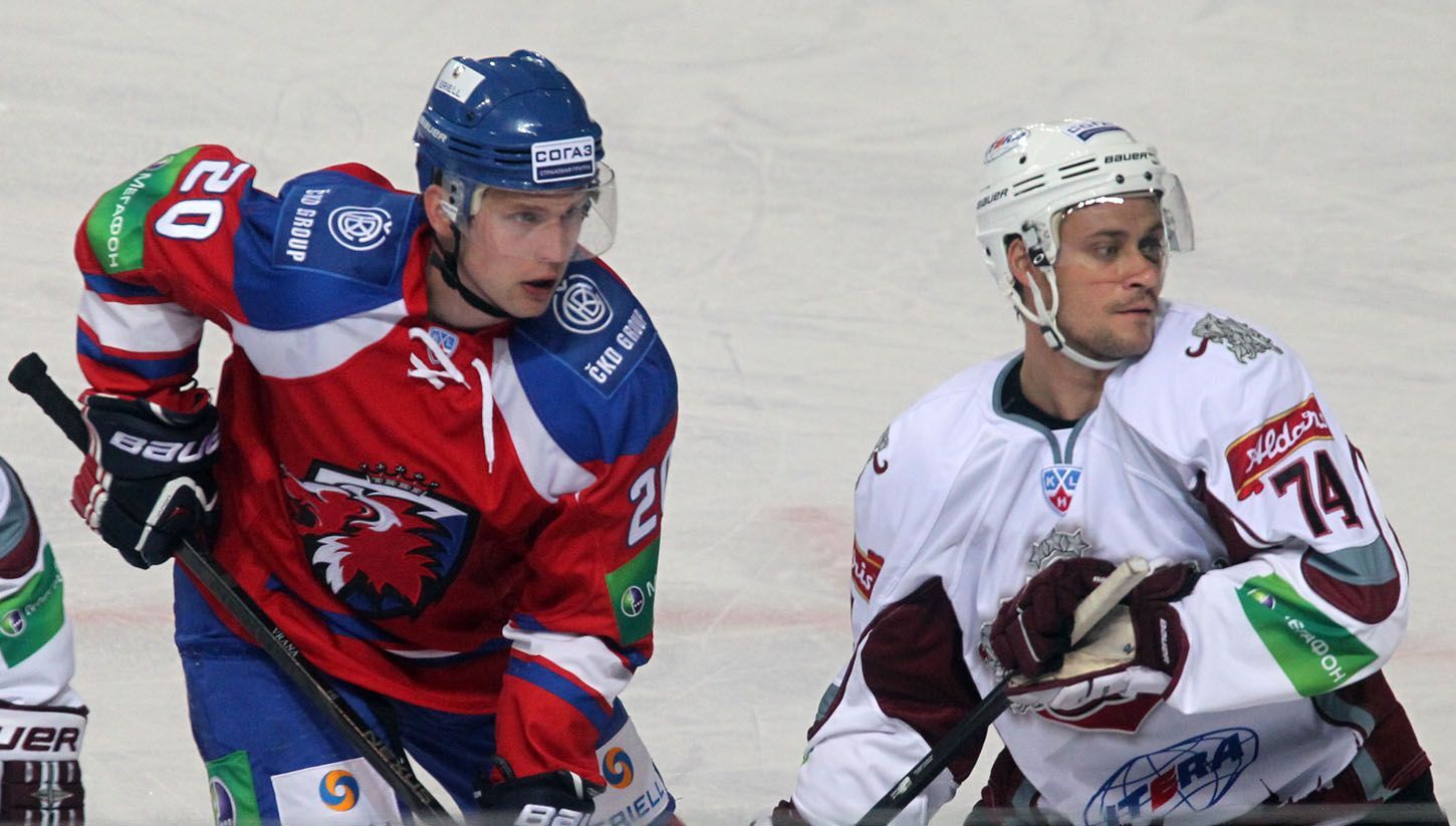 Hokejista Petr Vrána (vlevo) si hlídá Jamieho Johnsona v utkání KHL 2012/13 mezi Lvem Praha s Dinamem Riga .