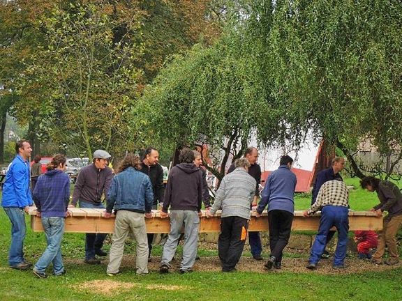 Brigádníci na plovárně u Malovarského rybníku přinášejí novou lavičku. Ten s kšiltovkou je budoucí starosta.