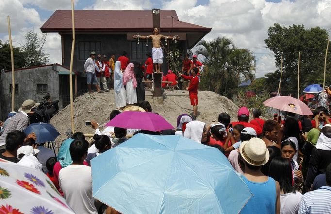 Renato Cunanan, 48, who portrays Jesus Christ, is nailed on a wooden cross during a Good Friday crucifixion re-enactment in San Juan village, Pampanga province, north of Manila March 29, 2013. The Roman Catholic church frowns on the gory spectacle held in the Philippine village of Cutud every Good Friday but that does nothing to deter the faithful from emulating the suffering of Christ and taking a painful route to penitents. Holy Week is celebrated in many Christian traditions during the week before Easter. REUTERS/Romeo Ranoco (PHILIPPINES - Tags: RELIGION SOCIETY) Published: Bře. 29, 2013, 4:59 dop.