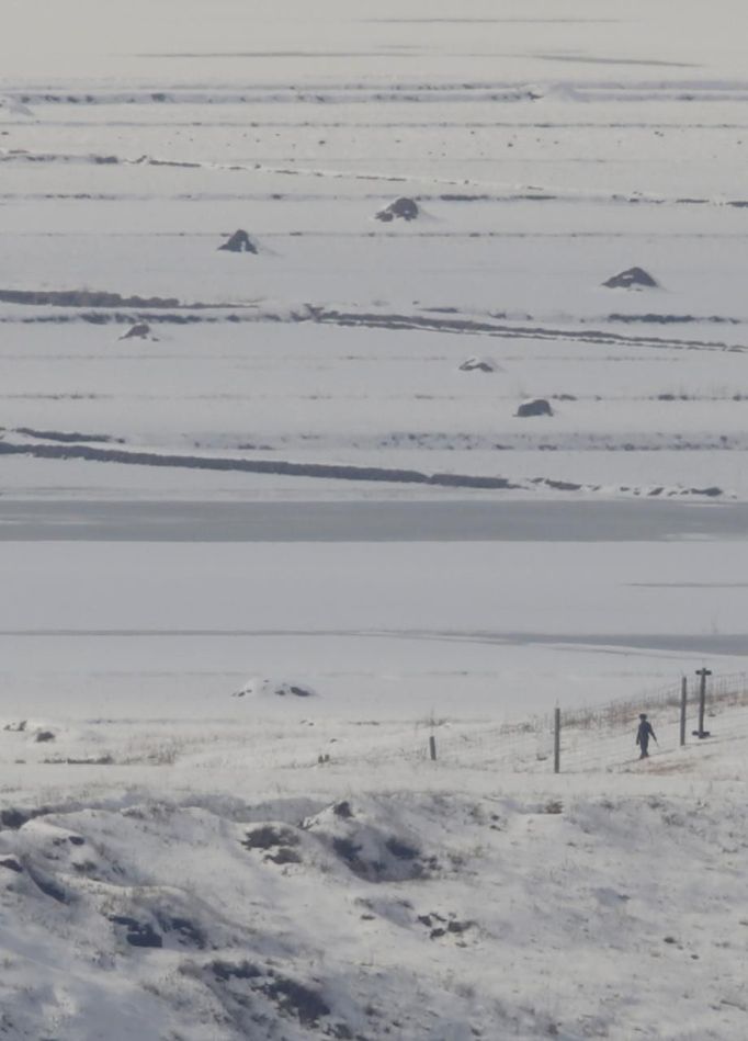 A North Korean soldier (bottom R) patrols along the military fence in the village of Gijungdong, North Korea, in this picture taken from a South Korean observation post, just south of the demilitarized zone separating the two Koreas, in Paju, north of Seoul, February 6, 2013. New York under missile attack is a remote dream for impoverished North Korea, yet that is precisely what the latest propaganda video from the isolated state shows as it readies a third nuclear test. North Korea has trailed plans to carry out a third nuclear test, which experts believe is imminent. REUTERS/Lee Jae-Won (SOUTH KOREA - Tags: MILITARY POLITICS ENERGY) Published: Úno. 6, 2013, 8:07 dop.