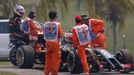 Lotus Formula One driver Romain Grosjean of France is driven back to pits after leaving his car during the second practice session of the Malaysian F1 Grand Prix at Sepan