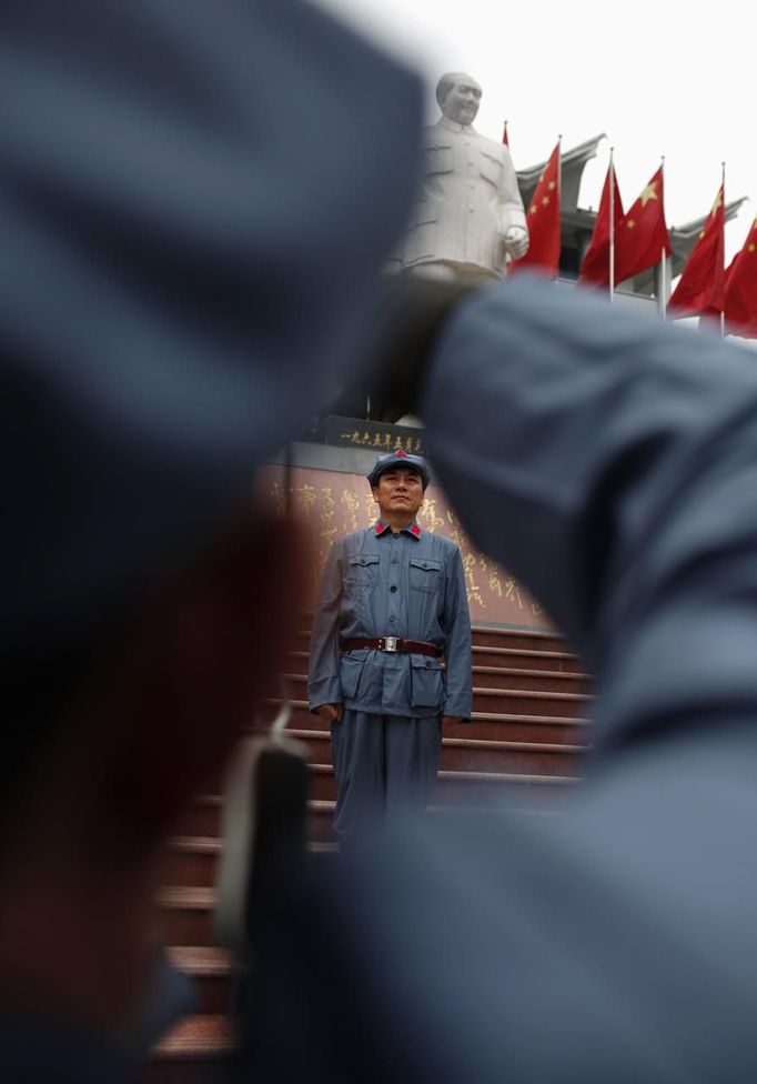 A visitor, dressed as a red army soldier, poses for a picture in Jinggangshan, Jiangxi province September 20, 2012. Jinggangshan, is where former Chinese leader Mao Zedong's career as a revolutionary began to take off. In 1927, Mao and several communist leaders fled with a few thousands to the hills of Jinggangshan, hounded and outnumbered by Nationalist forces. REUTERS/Carlos Barria (CHINA - Tags: POLITICS SOCIETY) Published: Zář. 20, 2012, 5:28 dop.