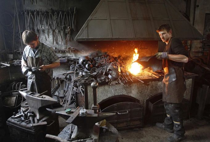 Blacksmith brothers Johann (R) and Georg Schmidberger work on harnesses for the Vatican Swiss Guard at their workshop in Molln, Upper Austria June 12, 2012. Johann, 29, and Georg, 28, produce made-to-order handmade harnesses for the Vatican, which take 120 hours of handiwork per piece and hardly differs from the 500-year-old originals. The brothers carry on the tradition of the blacksmith trade in the fifth generation of their family. REUTERS/Lisi Niesner (AUSTRIA - Tags: SOCIETY MILITARY) Published: Čer. 12, 2012, 10:03 odp.