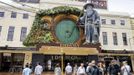 Pedestrians walk past a giant model of the J. R. R. Tolkien character Gandalf mounted on the front of The Embassy Theatre in Wellington November 27, 2012, where the world premier of The Hobbit film will screen on Wednesday. New Zealand's capital city was rushing to complete its transformation into a haven for hairy feet and pointed ears on Tuesday as stars jetted in for the long-awaited world premiere of the first movie of the Hobbit trilogy. REUTERS/Mark Coote (NEW ZEALAND - Tags: ENTERTAINMENT) Published: Lis. 27, 2012, 3:20 dop.