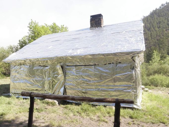 A cabin at White Creek is wrapped in protective foil to protect against high heat and fire, at the confluence of White Creek and West Fork, approximately 20 miles from Gila Center, New Mexico, in this United States Forest Service handout photo dated May 24, 2012. The so-called Whitewater-Baldy Complex fire was ignited by lightning on May 16, fire officials said. Picture taken May 24, 2012. REUTERS/USFS/Handout (UNITED STATES - Tags: ENVIRONMENT DISASTER) FOR EDITORIAL USE ONLY. NOT FOR SALE FOR MARKETING OR ADVERTISING CAMPAIGNS. THIS IMAGE HAS BEEN SUPPLIED BY A THIRD PARTY. IT IS DISTRIBUTED, EXACTLY AS RECEIVED BY REUTERS, AS A SERVICE TO CLIENTS Published: Kvě. 30, 2012, 8:37 odp.