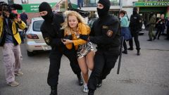 Příslušníci jednotek ministerstva vnitra OMON zasahují proti pochodu žen v Minsku.