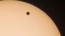 The planet Venus is seen through a special solar filter as a black dot while it transits across the sun in Berlin June 6, 2012. The planet Venus made a slow transit across the face of the sun on Tuesday, the last such passing that will be visible from Earth for 105 years. REUTERS/Fabrizio Bensch (GERMANY - Tags: ENVIRONMENT SCIENCE TECHNOLOGY) Published: Čer. 6, 2012, 6:05 dop.