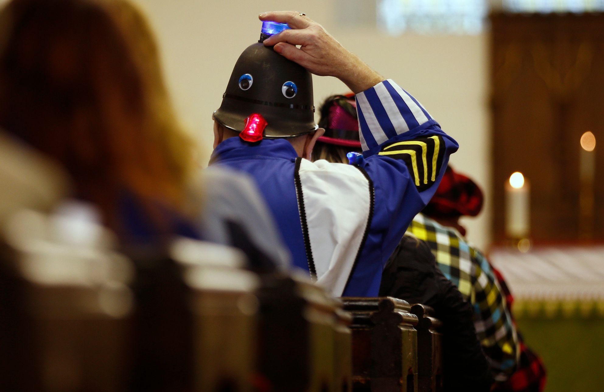 A clown sits in the pews of the All Saints Church during the Grimaldi clown service in Dalston, north London