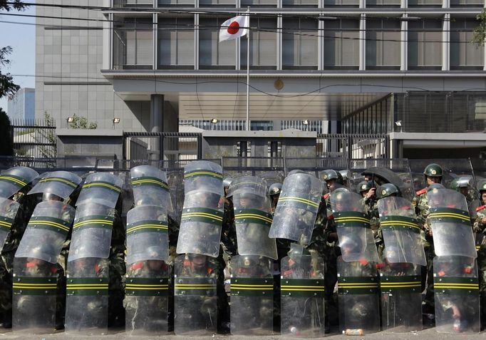 Protesters burn Japanese flags during a protest against Japan's purchase of the disputed Senkaku or Diaoyu islands outside the Japanese embassy in Beijing September 15, 2012. Thousands of protesters besieged the Japanese embassy in Beijing on Saturday, hurling rocks and bottles at the building as police struggled to keep control, amid growing tensions between Asia's two biggest economies over a group of disputed islands. REUTERS/Jason Lee (CHINA - Tags: POLITICS CIVIL UNREST)