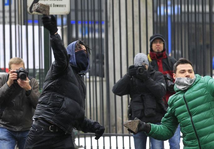 Arcelor Mittal workers from Liege throw stones during a demonstration outside Prime Minister Elio Di Rupo's office, where a political meeting is taking place, in Brussels January 25, 2013. ArcelorMittal, the world's largest steel producer, plans to shut a coke plant and six finishing lines at its site in Liege Belgium, affecting 1,300 employees, the group said on Thursday. REUTERS/Yves Herman (BELGIUM - Tags: BUSINESS CIVIL UNREST EMPLOYMENT) Published: Led. 25, 2013, 12:24 odp.