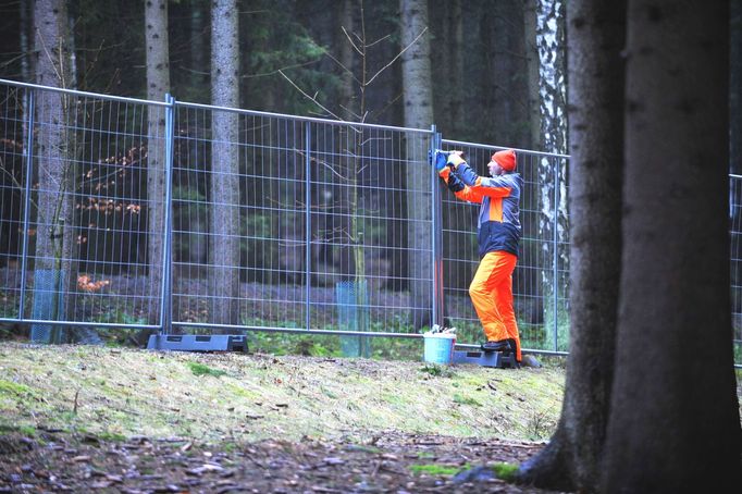 Dělník montuje oplocení, které jsou organizátoři nuceni přemístit.