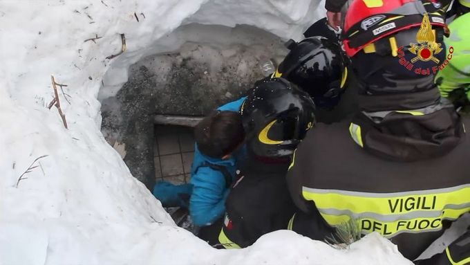 Italští záchranáři vytahují jednoho z přeživších z hotelu zavaleného lavinou.