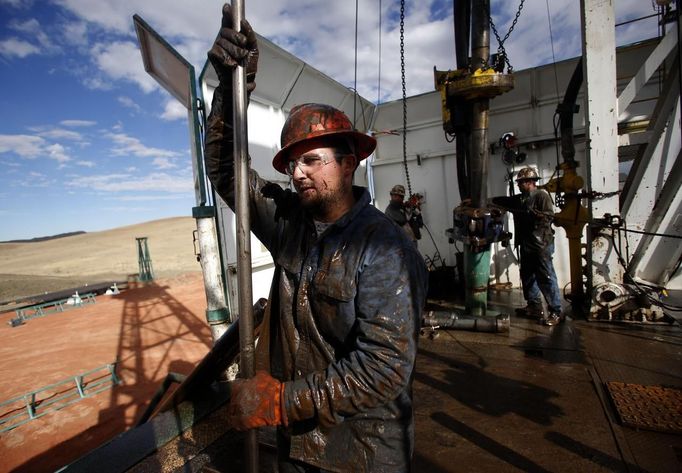 Roughneck Brian Waldner is covered in mud and oil while wrestling pipe on a True Company oil drilling rig outside Watford, North Dakota, October 20, 2012. Thousands of people have flooded into North Dakota to work in state's oil drilling boom. Picture taken October 20, 2012. REUTERS/Jim Urquhart (UNITED STATES - Tags: ENERGY BUSINESS EMPLOYMENT) Published: Říj. 22, 2012, 2:56 odp.