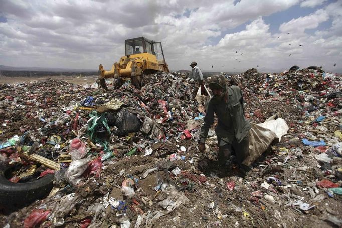 Men collect recyclable cans and bottles at a garbage disposal site near Sanaa