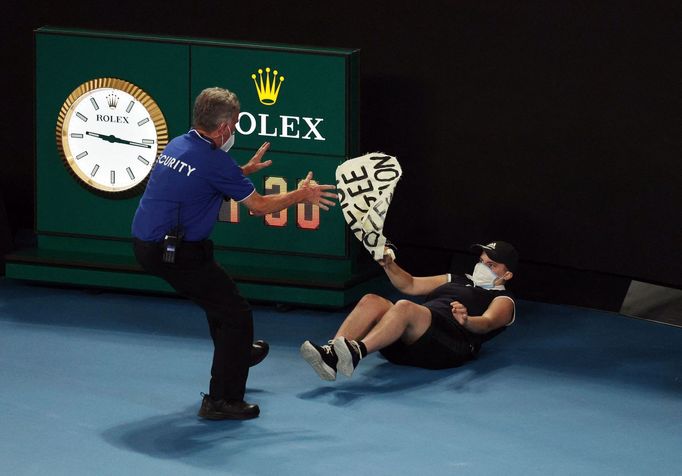 Ochranka odtahuje výtržníka, který vběhl na kurt během finále Australian Open 2022