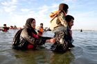 Voda dosahuje až k pasu, ale migranti se nevzdávají. V nepřehledném chaosu se snaží hlavně nezůstat pozadu.