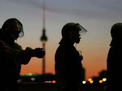 Němečtí policisté hlídkují v Berlíně, v pozadí silueta známé televizní věže.