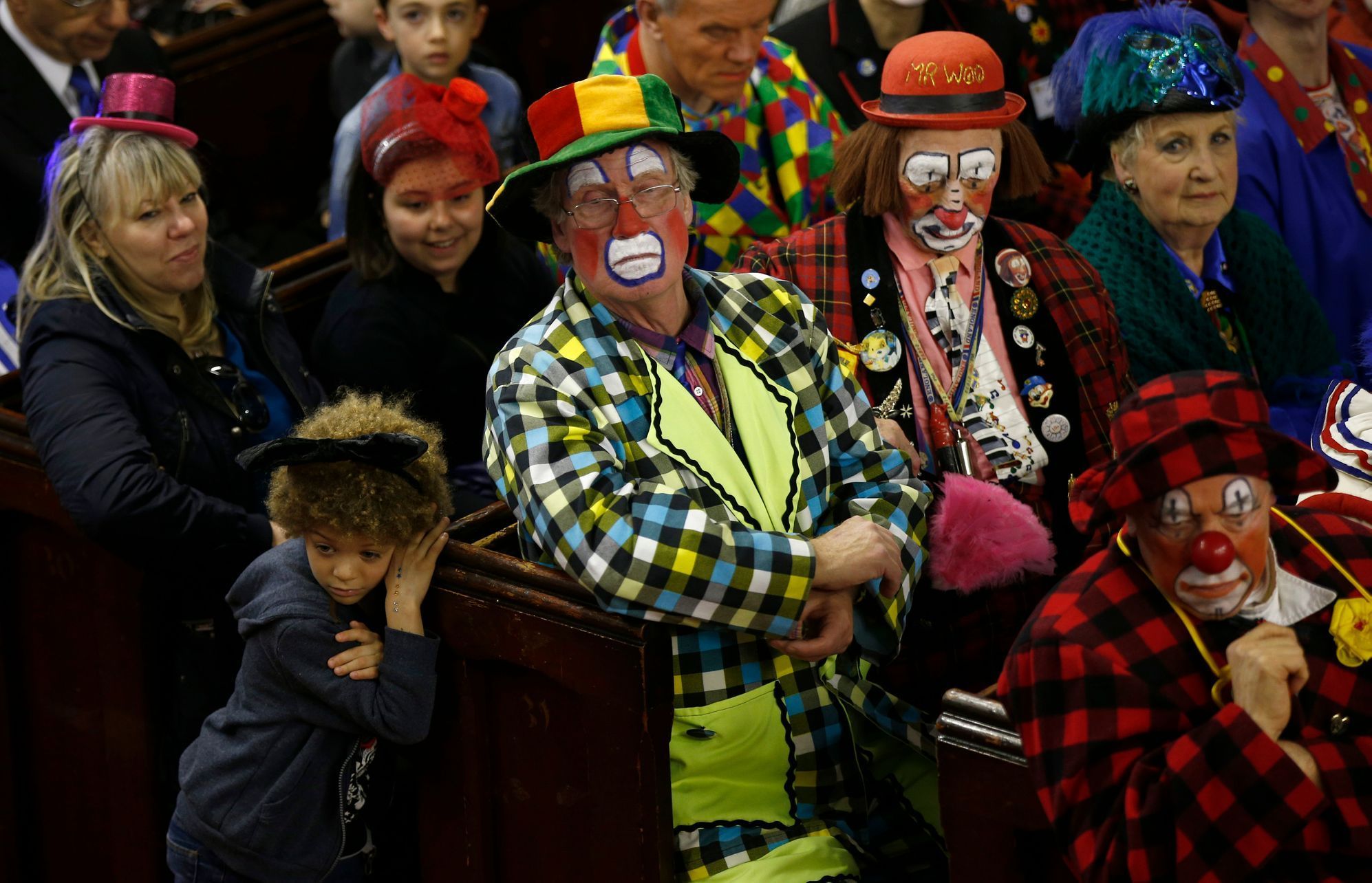 Clowns and members of the public sit in the pews of the All Saints Church during the Grimaldi clown service in Dalston, north London