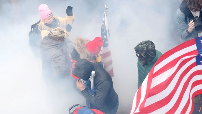 Stoupenci prezidenta Donalda Trumpa v oblaku slzného plynu při střetech s policií před budovou Kapitolu.