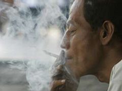 Ani tento indonéský pouliční prodavač nedokáže odolat kouzlu cigaretového dýmu