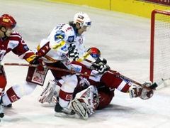 Igor Rataj ze Slavie Praha (uprostřed) překonává třineckého brankáře Martina Vojtka v utkání 45. kola hokejové extraligy.