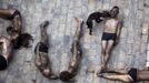 Animal rights protesters lie covered in black paint as they form the words "Stop bullfighting" during a demonstration calling for the abolition of bull runs and bullfights, a day before the start of the famous running of the bulls San Fermin festival in Pamplona July 5, 2012. The annual week-long fiesta gets underway July 6, with the first bull run in the morning of July 7. REUTERS/Susana Vera (SPAIN - Tags: CIVIL UNREST SOCIETY POLITICS) Published: Čec. 5, 2012, 12:19 odp.