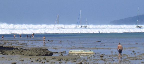 Turisté na písečné pláži po ustoupení vody, když se k Hat Rai Lay Beach na jihu Thajska 26. prosince 2004 začala blížit první ze šesti tsunami.