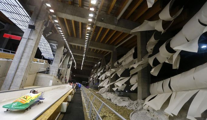 Protection blinds flutter due to heavy winds during the two-woman bobsleigh competition test event at the "Sanki" siding center in Rosa Khutor, a venue for the Sochi 2014 Winter Olympics near Sochi February 15, 2013. The Sochi 2014 Winter Olympics opens on February 7, 2014. REUTERS/Kai Pfaffenbach (RUSSIA - Tags: SPORT SPEED SKATING OLYMPICS) Published: Úno. 15, 2013, 5:51 odp.