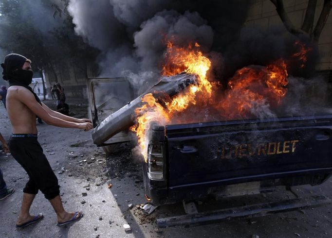 A protester sets fire to police vehicles during clashes with riot police along a road which leads to the U.S. embassy, near Tahrir Square in Cairo September 13, 2012. Egypt's President Mohamed Mursi said on Thursday he supported peaceful protests but not attacks on embassies, after Egyptians angry at a film deemed insulting to the Prophet Mohammad climbed into the U.S. embassy in Cairo and tore down the U.S. flag. He pledged to protect foreigners in Egypt.