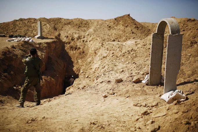 An Israeli soldier takes a picture of an entrance to a tunnel exposed by the Israeli military, just outside the southern Gaza Strip