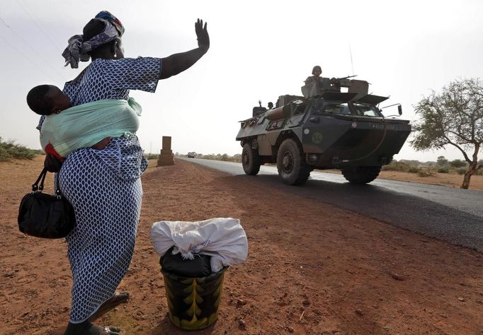 A woman waves to French soldiers, which is part of a convoy of French military vehicles including armored personnel carriers, jeeps and supply trucks, heading toward the recently liberated town of Diabaly January 24, 2013. REUTERS/Eric Gaillard (MALI - Tags: CIVIL UNREST CONFLICT MILITARY) Published: Led. 24, 2013, 4:50 odp.