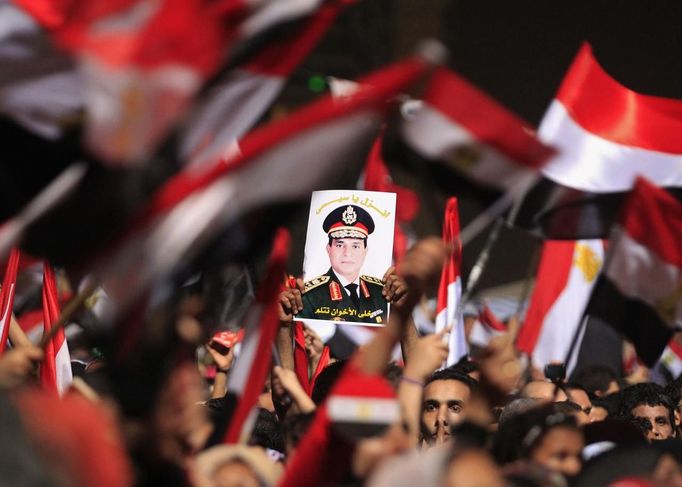 Protesters, who are against Egyptian President Mohamed Mursi, hold a poster featuring the head of Egypt's armed forces General Abdel Fattah al-Sisi in Tahrir Square in Cairo July 3, 2013. Egypt's armed forces overthrew elected Islamist President Mohamed Mursi on Wednesday and announced a political transition with the support of a wide range of political, religious and youth leaders. A statement published in Mursi's name on his official Facebook page after al-Sisi's speech said the measures announced amounted to "a full military coup" and were "totally rejected". REUTERS/Mohamed Abd El Ghany (EGYPT - Tags: POLITICS CIVIL UNREST MILITARY TPX IMAGES OF THE DAY) Published: Čec. 3, 2013, 9:11 odp.