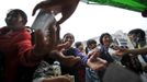 People receive milk packs as relief aid after Saturday's earthquake hit Lushan county, Ya'an, Sichuan province, April 22, 2013. Hundreds of survivors of an earthquake that killed nearly 200 people in southwest China pushed into traffic on a main road on Monday, waving protest signs, demanding help and shouting at police. Picture taken April 22, 2013. REUTERS/Stringer (CHINA - Tags: DISASTER SOCIETY) Published: Dub. 23, 2013, 3:47 dop.