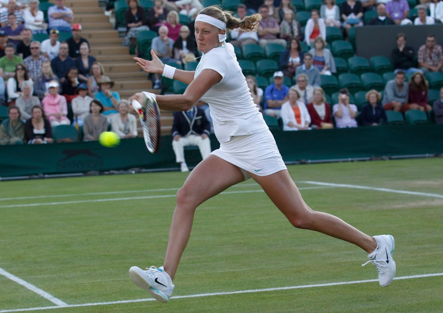 Česká tenistka Petra Kvitová vrací míček Britce Eleně Baltachaové během utkání Wimbledonu 2012.