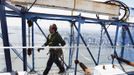 An iron worker walks on a walkway that hangs on the outside of the 100th story of One World Trade Center in New York, April 30, 2012. The addition of iron columns to the 100th story pushed the height of One World Trade above that of the Empire State Building today. REUTERS/Lucas Jackson (UNITED STATES - Tags: CITYSPACE SOCIETY BUSINESS CONSTRUCTION) Published: Dub. 30, 2012, 11:49 odp.