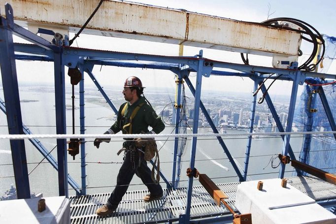 An iron worker walks on a walkway that hangs on the outside of the 100th story of One World Trade Center in New York, April 30, 2012. The addition of iron columns to the 100th story pushed the height of One World Trade above that of the Empire State Building today. REUTERS/Lucas Jackson (UNITED STATES - Tags: CITYSPACE SOCIETY BUSINESS CONSTRUCTION) Published: Dub. 30, 2012, 11:49 odp.