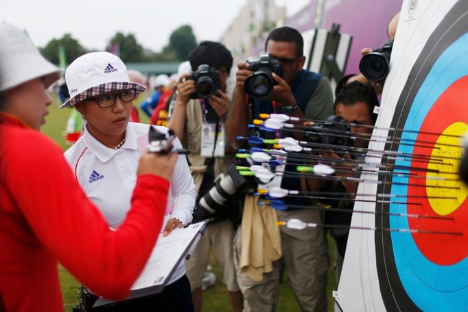 Jihokorejská lukostřelkyně Lee Jin-Sung (druhá zleva) si prohlíží výsledek během první kvalifikační střelby OH 2012 v Londýně.