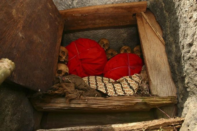 Bodies and skulls are seen in a stone grave called "Liang" during a ritual in the Toraja district of Indonesia's South Sulawesi Province, August 23, 2012. The ritual, called Ma'nene, involves changing the clothes every three years of mummified ancestors to honor love for the deceased. Locals believe dead family members are still with them, even if they died hundreds of years ago, a family spokesman said. Picture taken August 23, 2012. REUTERS/Yusuf Ahmad (INDONESIA - Tags: SOCIETY RELIGION) Published: Srp. 24, 2012, 1:09 odp.