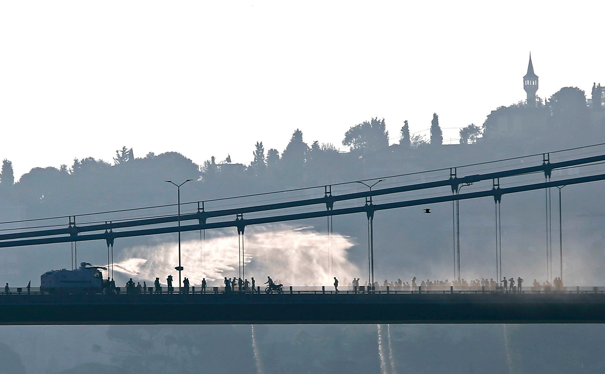 Policejní obrněný vůz s vodním dělem v akci na mostě přes Bospor v Istanbulu potlačují protivládní jednotky