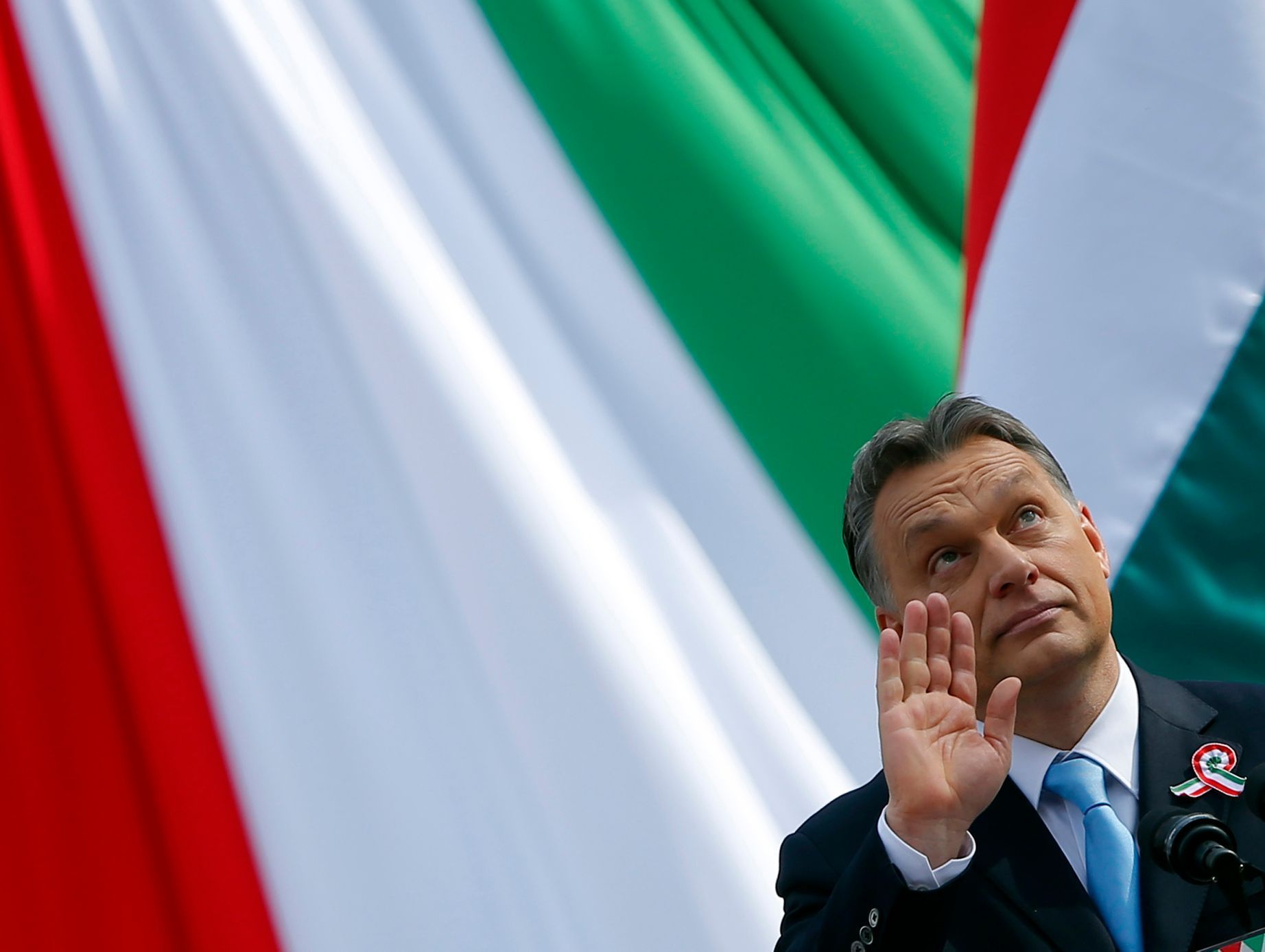 Hungarian Prime Minister Orban waves as he delivers a speech during the 166th anniversary of the anti-Habsburg revolution in Budapest