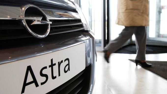 Zaměstnanec autosalónu Opel kráčí kolem modelu Astra v pobočce v Antverpách.
