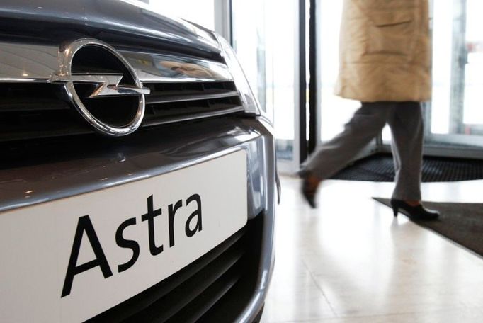 Zaměstnanec autosalónu Opel kráčí kolem modelu Astra v pobočce v Antverpách.