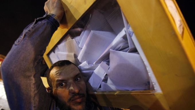 Pracovník volební komise přenáší urnu s hlasovacími lístky v Alexandrii.