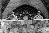 Dělníci pod dohledem vojáků a policistů při stavbě zdi. Píše se 13. srpen 1961.